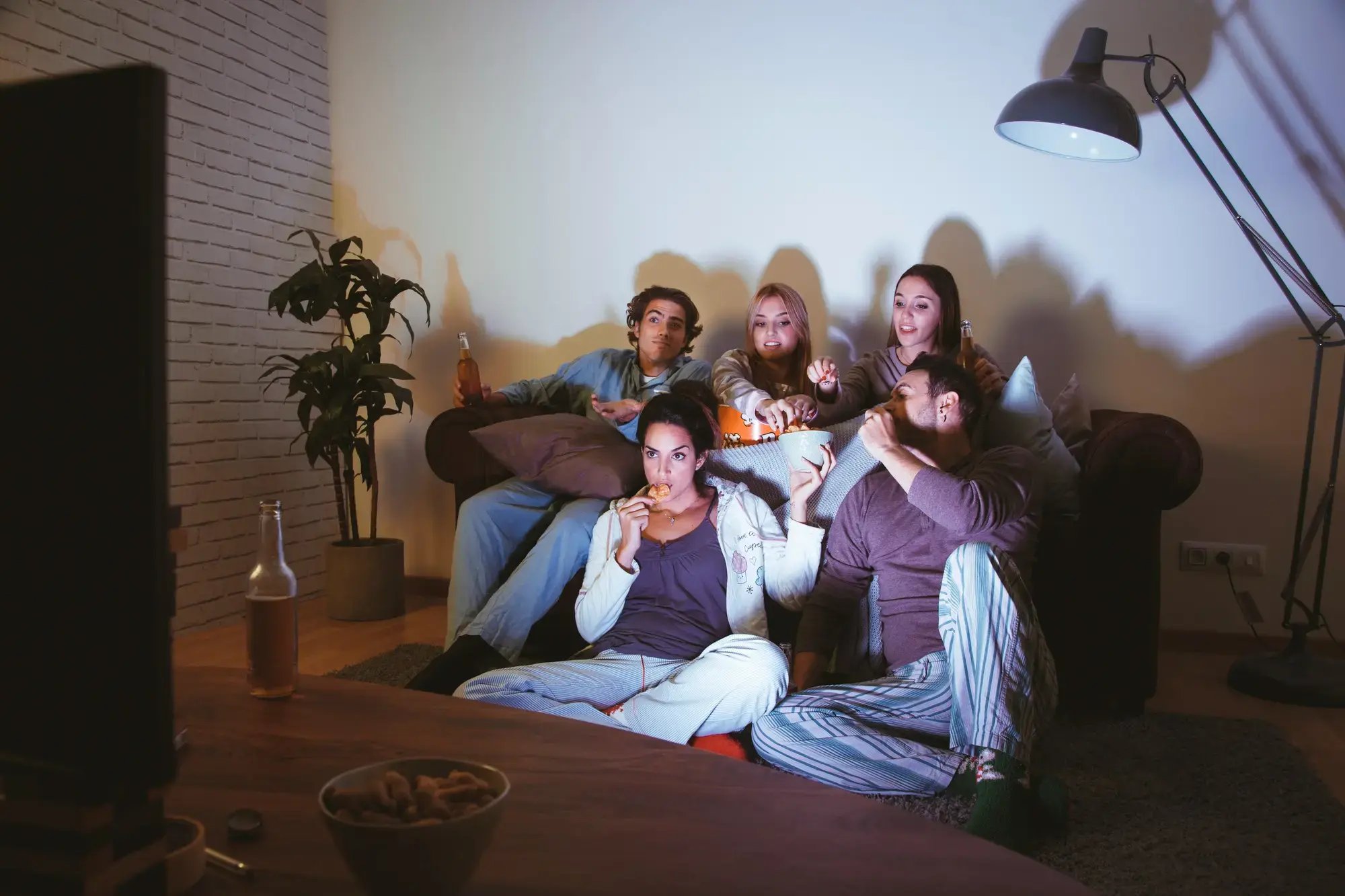 Una familia sentados en un sofá, disfrutando una película