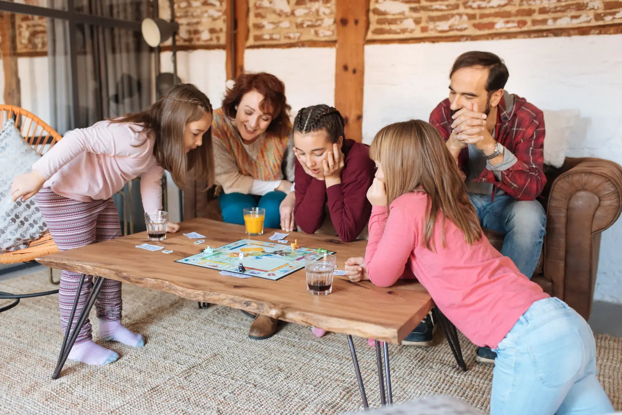 Una familia de padre, madre y tres hijas, divirtiéndose con un juego de mesa