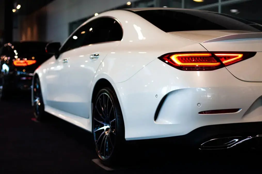 Automóvil blanco de lujo visto desde la parte trasera en un showroom