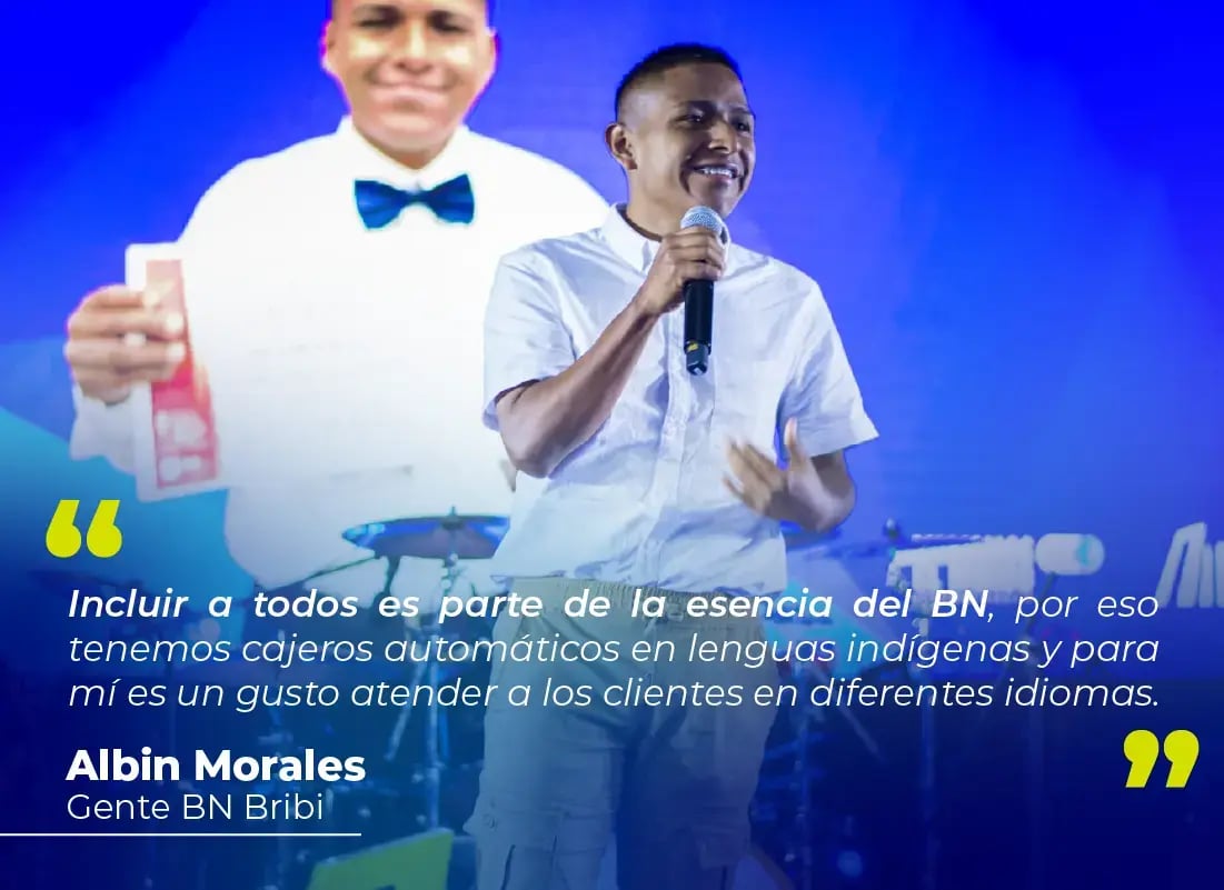 Hombre hablando en escenario con micrófono durante evento del Banco Nacional, con cita sobre inclusión en lenguas indígenas proyectada detrás.