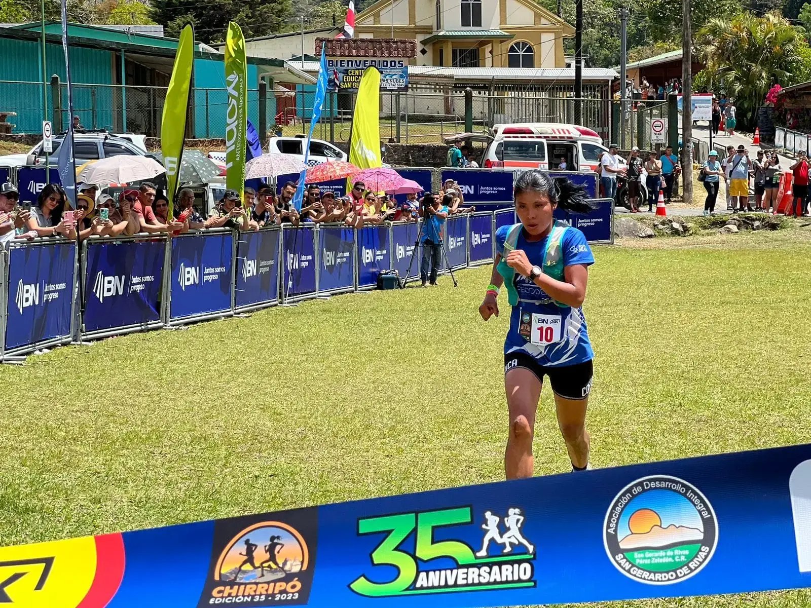 Atleta cruza la meta en la edición 35 de la carrera Chirripó 2023 patrocinada por el Banco Nacional, con público alentando en el fondo.