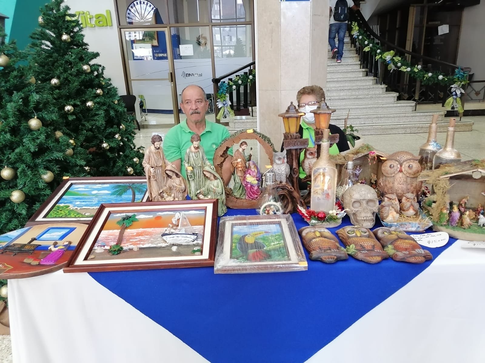 Artesano expone cuadros y piezas artesanales en la feria navideña del Banco Nacional.
