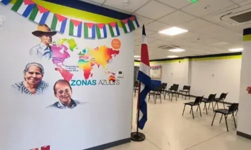 Mural de zonas azules en oficina del Banco Nacional con mapa y retratos de personas mayores