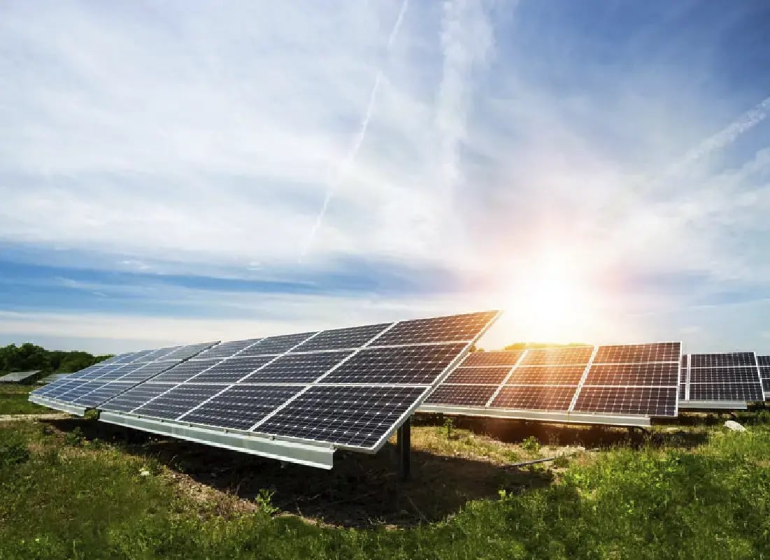 Paneles solares instalados en un campo verde generando energía con la luz del sol.