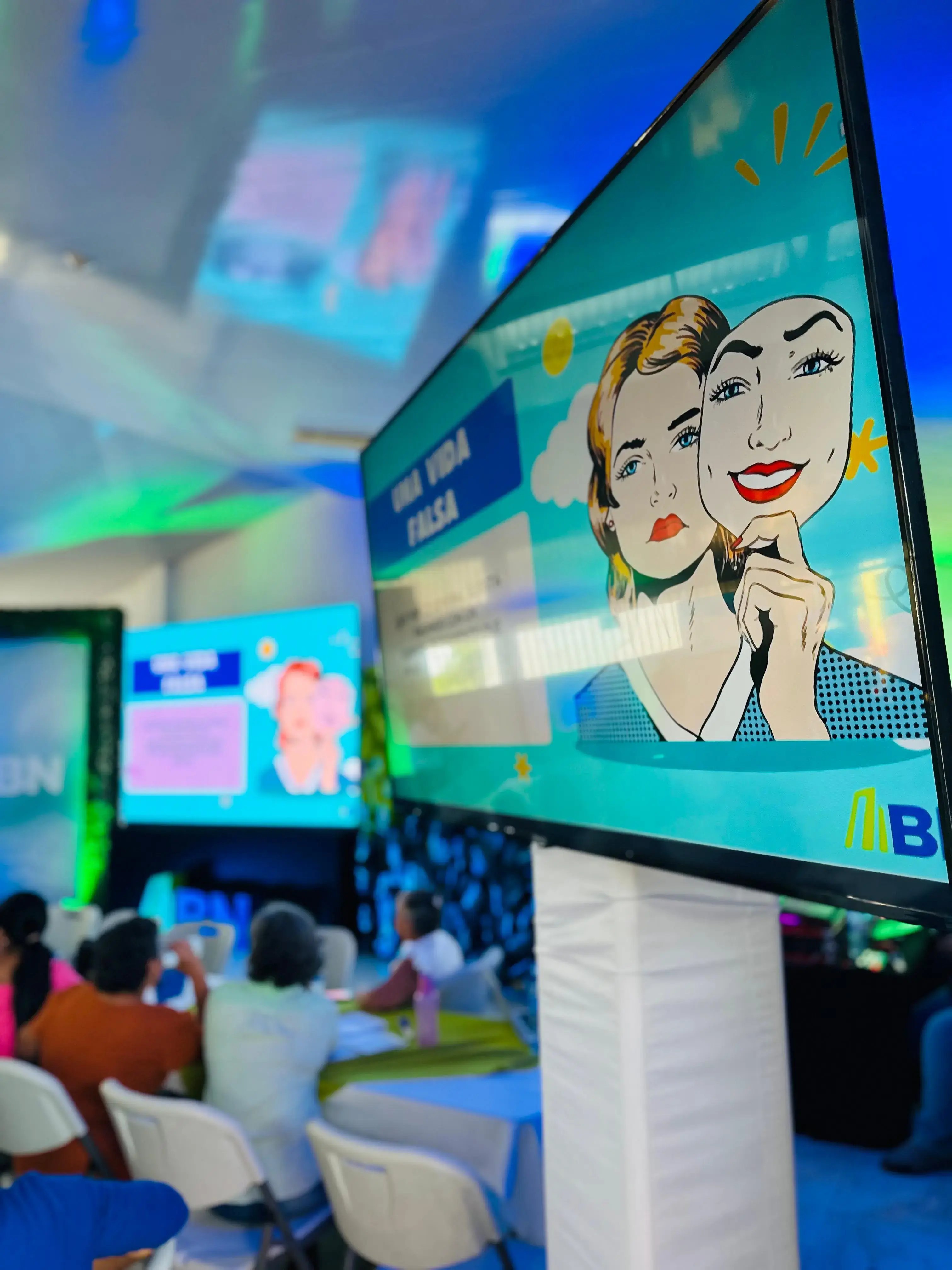 Pantalla con ilustración de una mujer sosteniendo una máscara sonriente durante una charla del Banco Nacional.