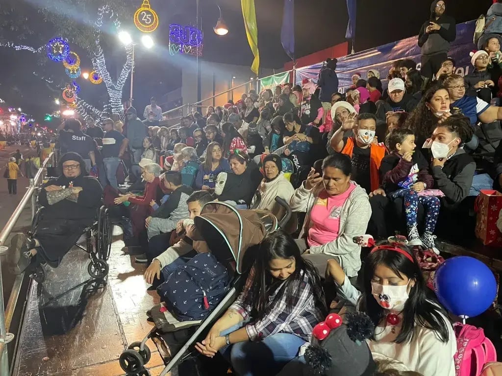 Público observando el desfile nocturno de carrozas en Costa Rica.