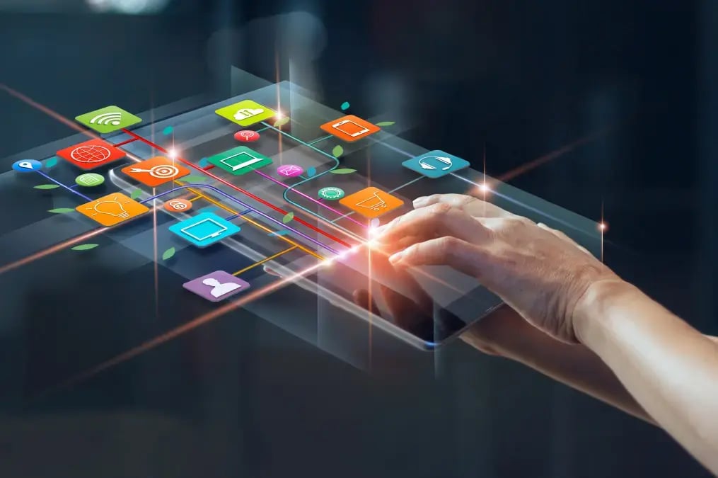 Mano utilizando una tablet con íconos de aplicaciones digitales flotando.