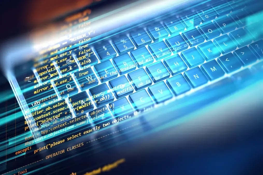 Teclado iluminado con líneas de código de programación en pantalla digital.