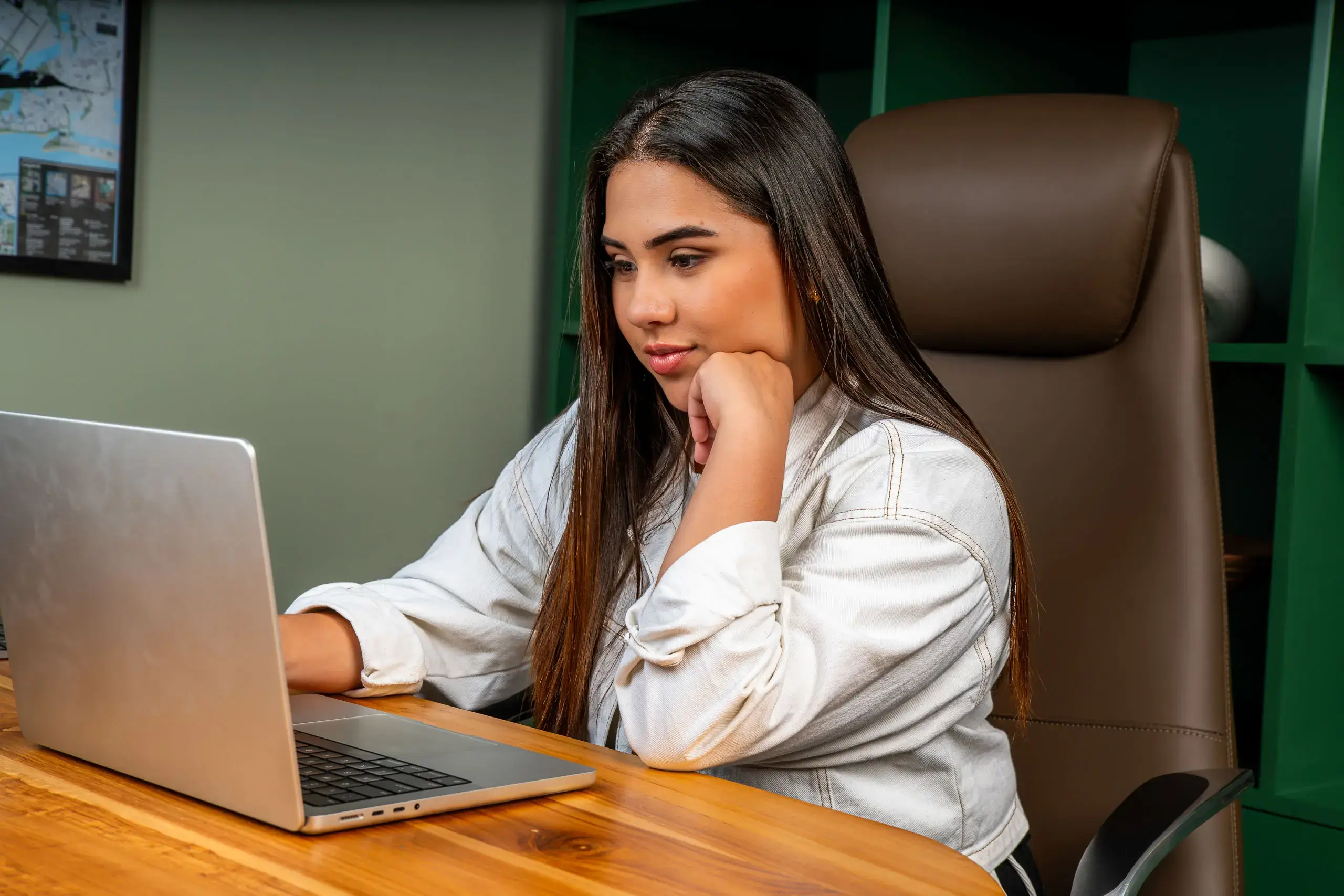 Mujer joven usando una computadora portátil mientras trabaja en una oficina.