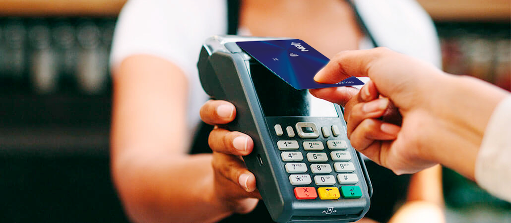 Persona realizando un pago sin contacto con tarjeta en un datáfono