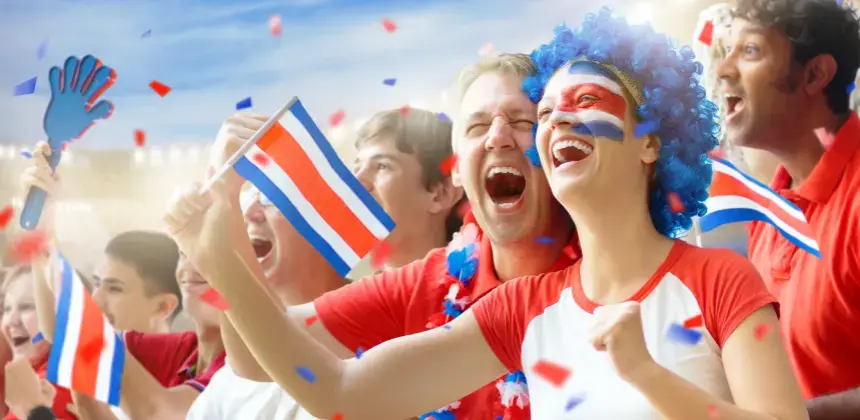 Aficionados celebrando en estadio con banderas de Costa Rica y pintados con los colores nacionales