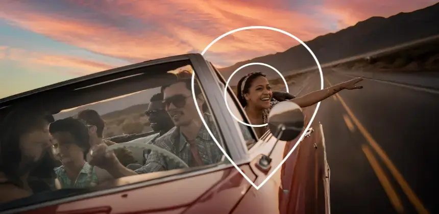 Grupo de amigos viajando en un auto descapotable al atardecer en carretera