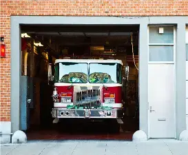 Camión de bomberos estacionado en su base, listo para atender emergencias comunitarias.