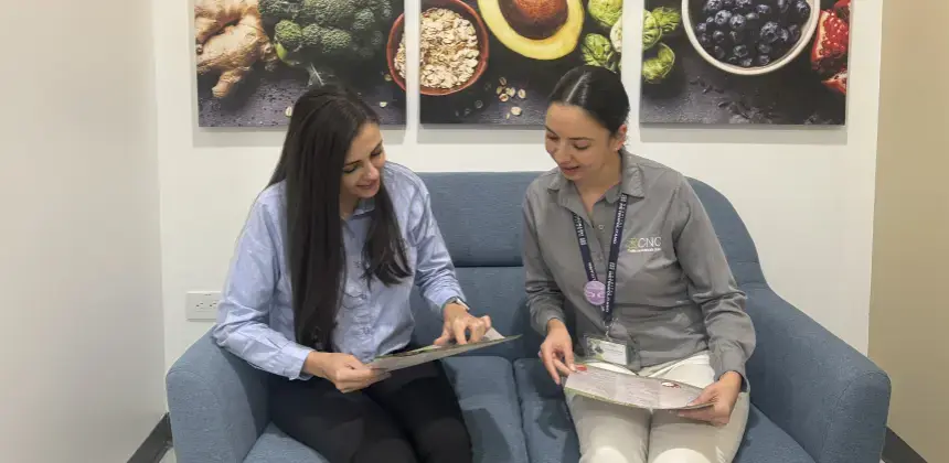 Nutricionista del Centro de Nutrición Clínica conversando con paciente mientras revisan plan alimenticio