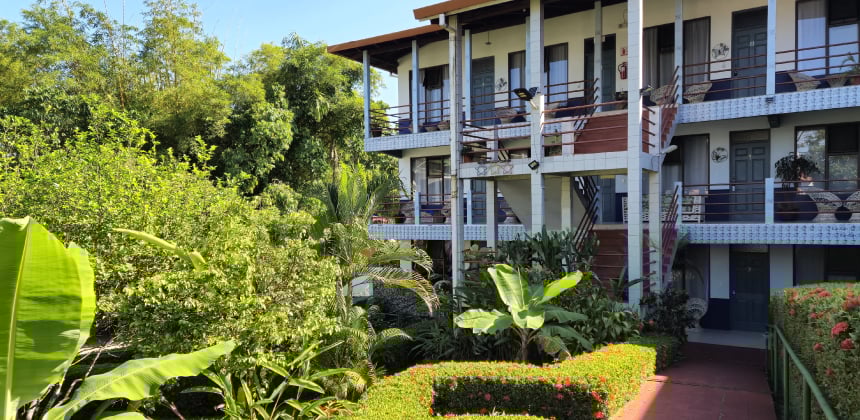 Fachada del Hotel Divisamar rodeada de jardines tropicales y vegetación exuberante
