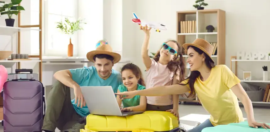Familia con sombreros y maletas planea sus vacaciones usando una laptop mientras una niña sostiene un avión de juguete