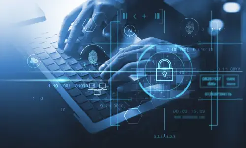 Manos escribiendo en un teclado con gráficos digitales superpuestos relacionados con ciberseguridad y protección de datos