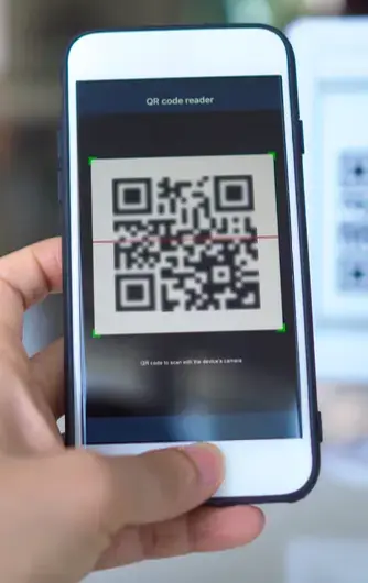 Persona escaneando un código QR en la pantalla de un teléfono inteligente.