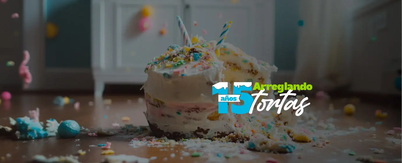 Pastel de cumpleaños caído en el suelo con velas encendidas y decoraciones esparcidas