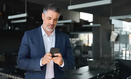Hombre de negocios usando un teléfono móvil en una oficina moderna y elegante