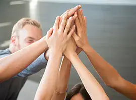 Grupo de personas chocando las palmas en señal de trabajo en equipo o logro conjunto.