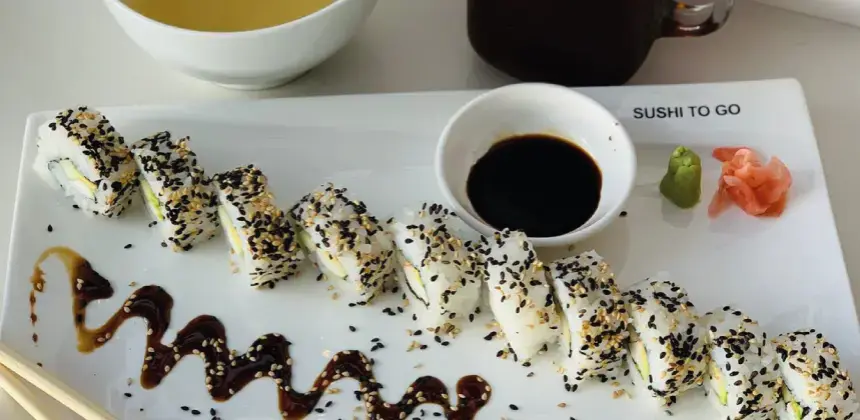 Plato de sushi con semillas de sésamo, salsa de soya, wasabi y jengibre en restaurante Sushi To Go