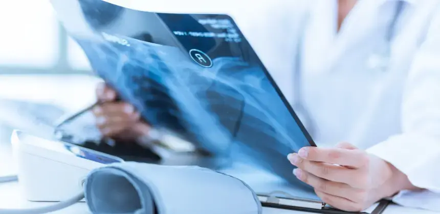 Profesional de salud revisando radiografía de tórax en consultorio médico