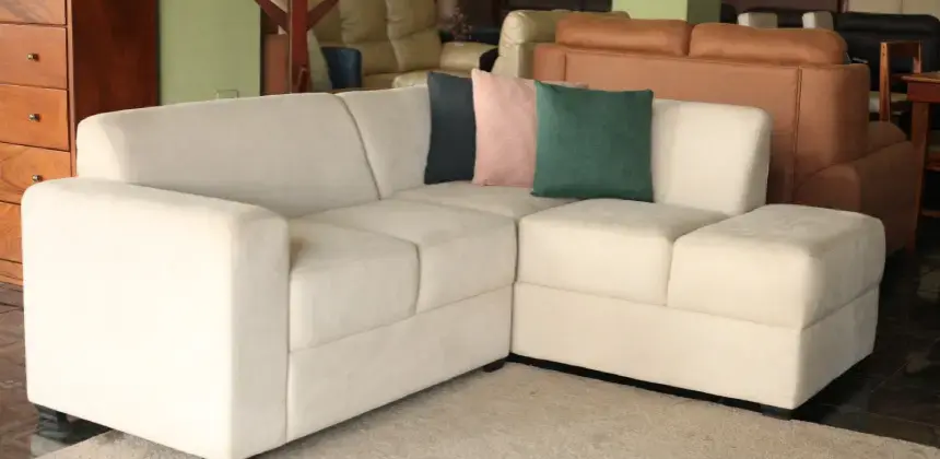 Sofá esquinero beige con cojines decorativos en sala de exhibición de Mueblería Pérez Luna