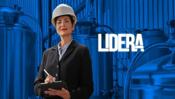 Mujer con casco de seguridad y traje formal, sosteniendo una libreta y bolígrafo en una planta industrial, con la palabra 