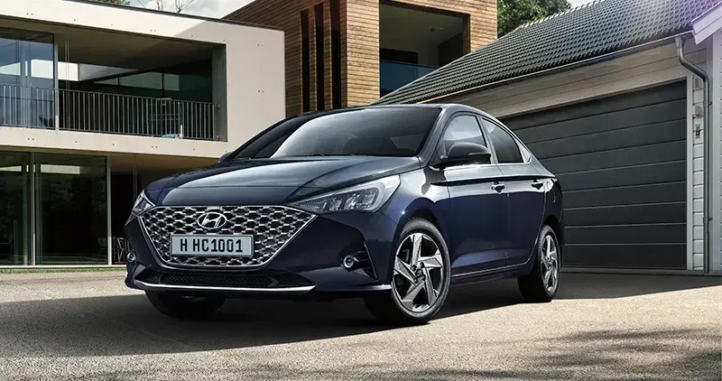 Automóvil Hyundai estacionado frente a una casa moderna, representando propiedad vehicular o adquisición de activos automotrices.