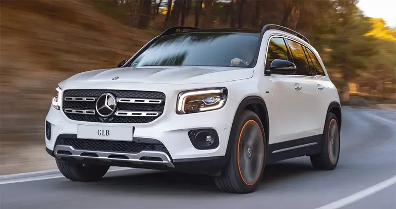 Vehículo SUV Mercedes-Benz circulando en carretera entre árboles, representando movilidad, lujo y propiedad automotriz.