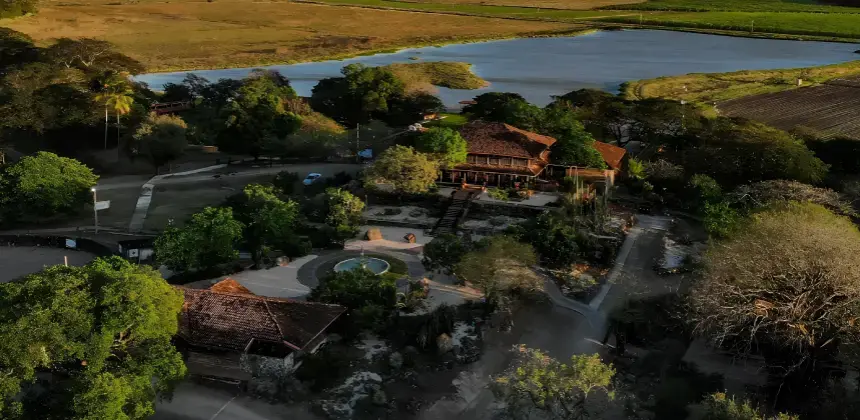 Vista aérea de Hacienda El Viejo rodeada de vegetación, laguna y paisajes naturales en Guanacaste